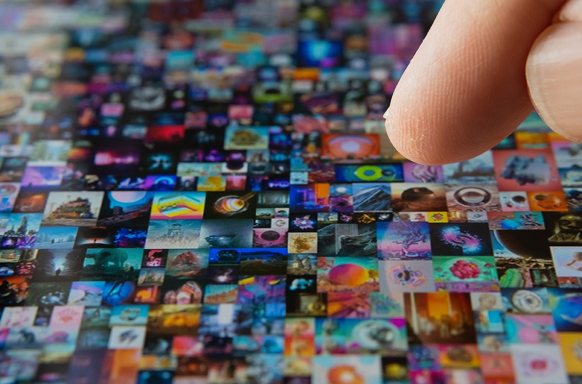 A person's finger is pointing at a collage of images featuring NFTs.