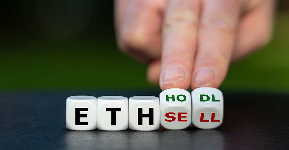 A person is holding dice embedded with the words eth, DHL, and sell, exemplifying the integration of blockchain technology in the crypto space.