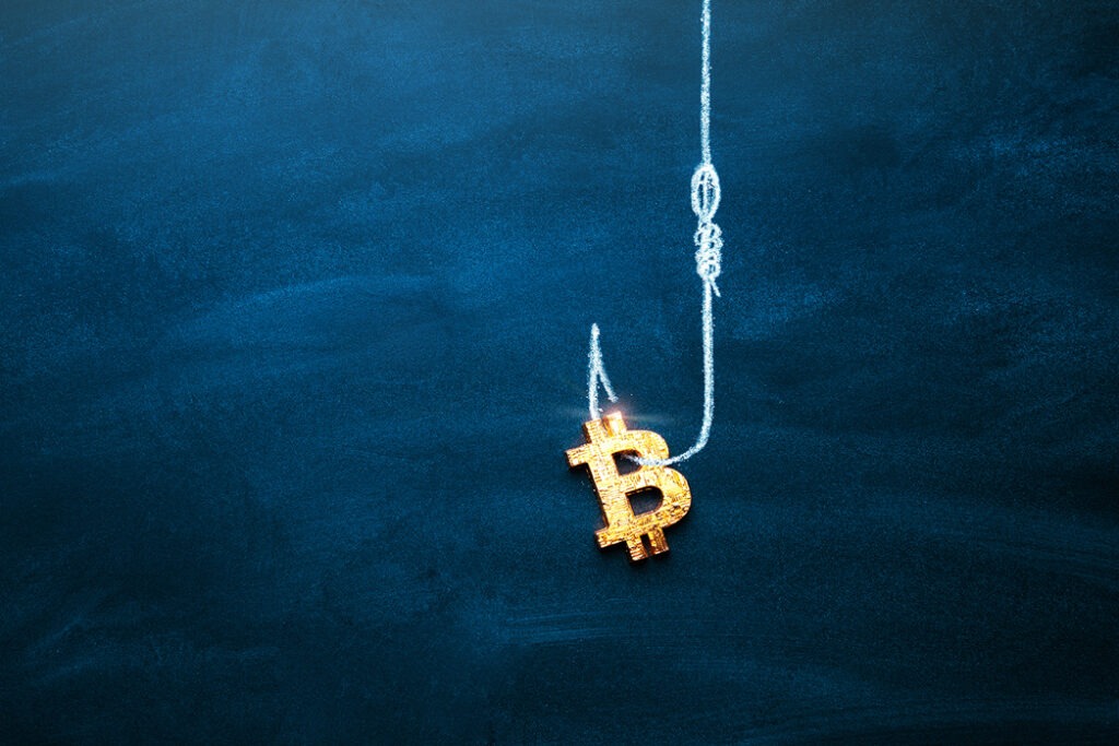 Cryptocurrency scams Bitcoin hooked by a fishing hook on blue background.