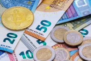 Bitcoin and Euro banknotes and coins.
